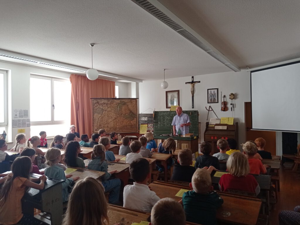 Klassenzimmer mit Schülern und Lehrer in alter Schule