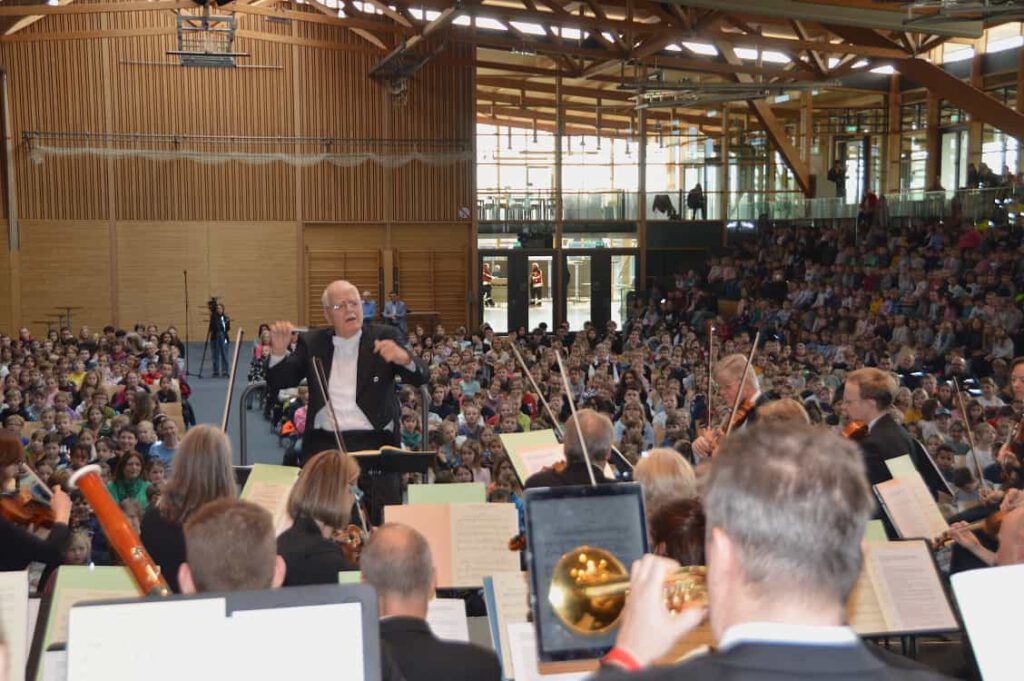Dirigent leitet Orchester vor großem Publikum Indoor