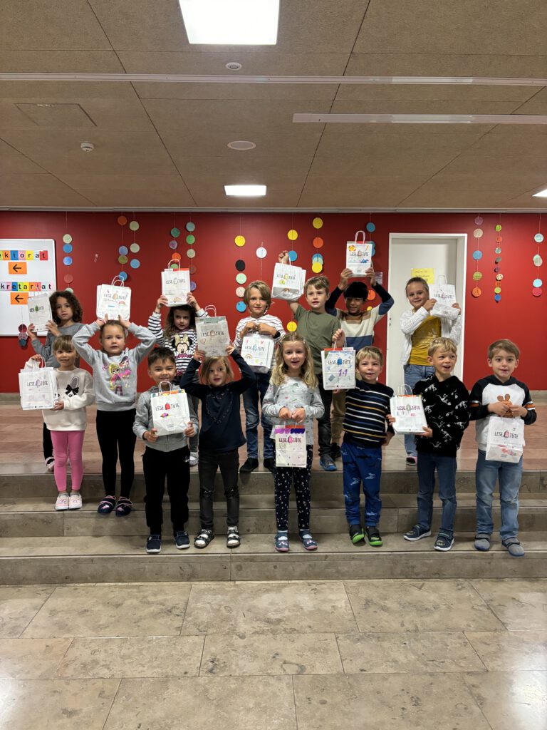 Kinder in einer Schule halten Zeichnungen hoch