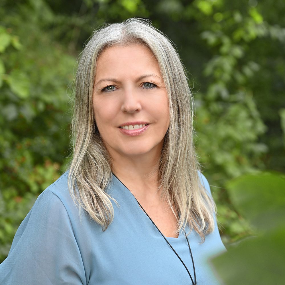 Rektorin vor grünem Hintergrund