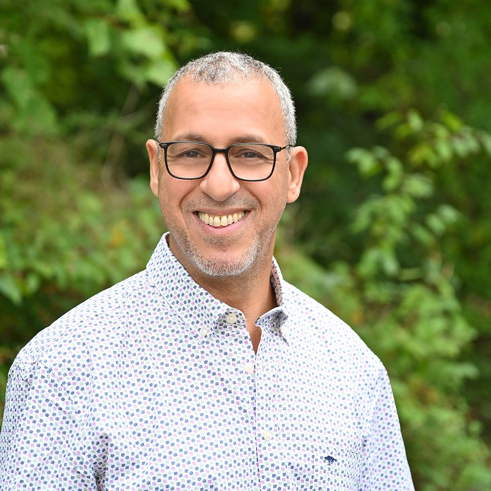 Hausmeister steht vor grünem Hintergrund