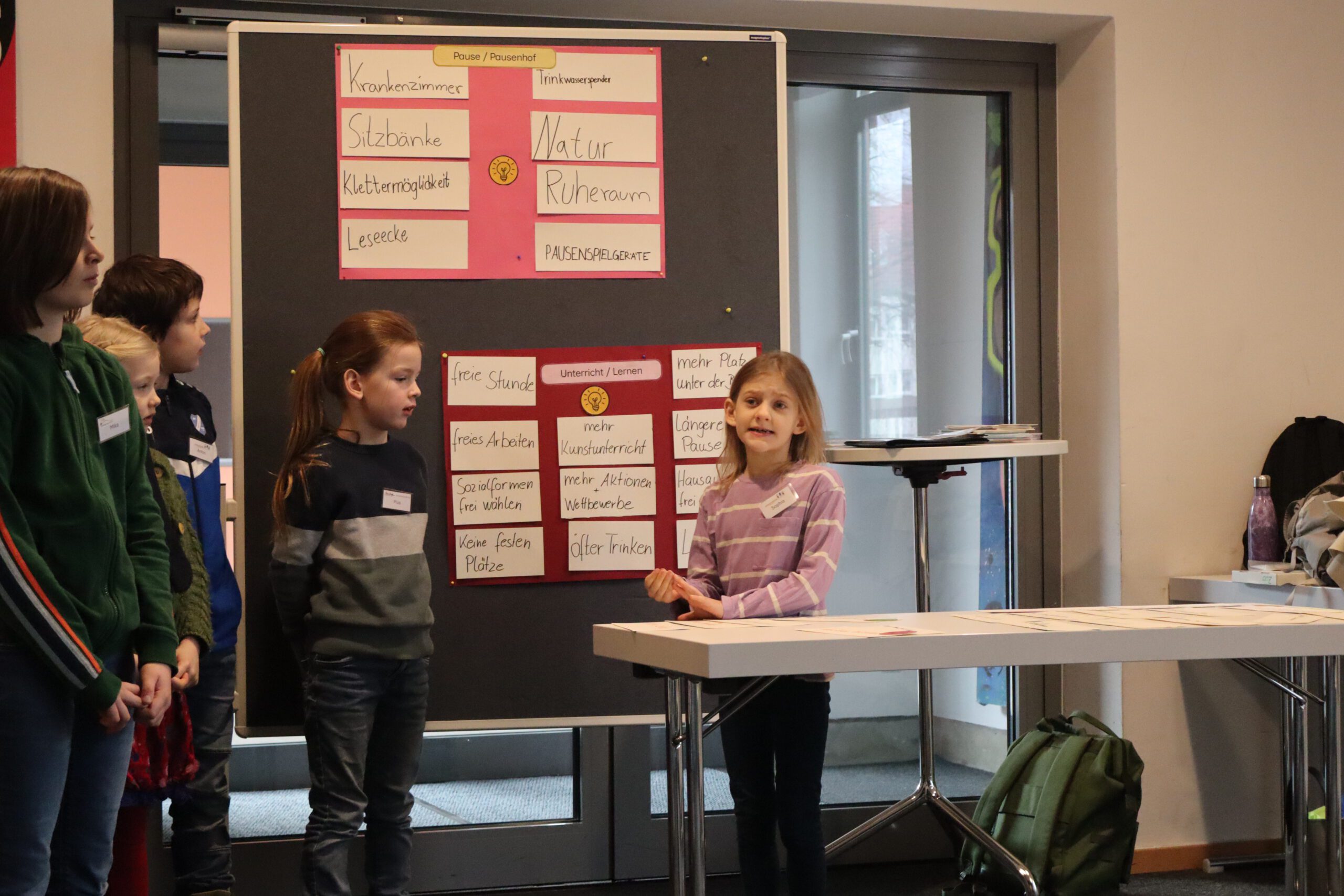 Zwei Mädchen stehen vor einer Schautafel und erklären ihr Plakat