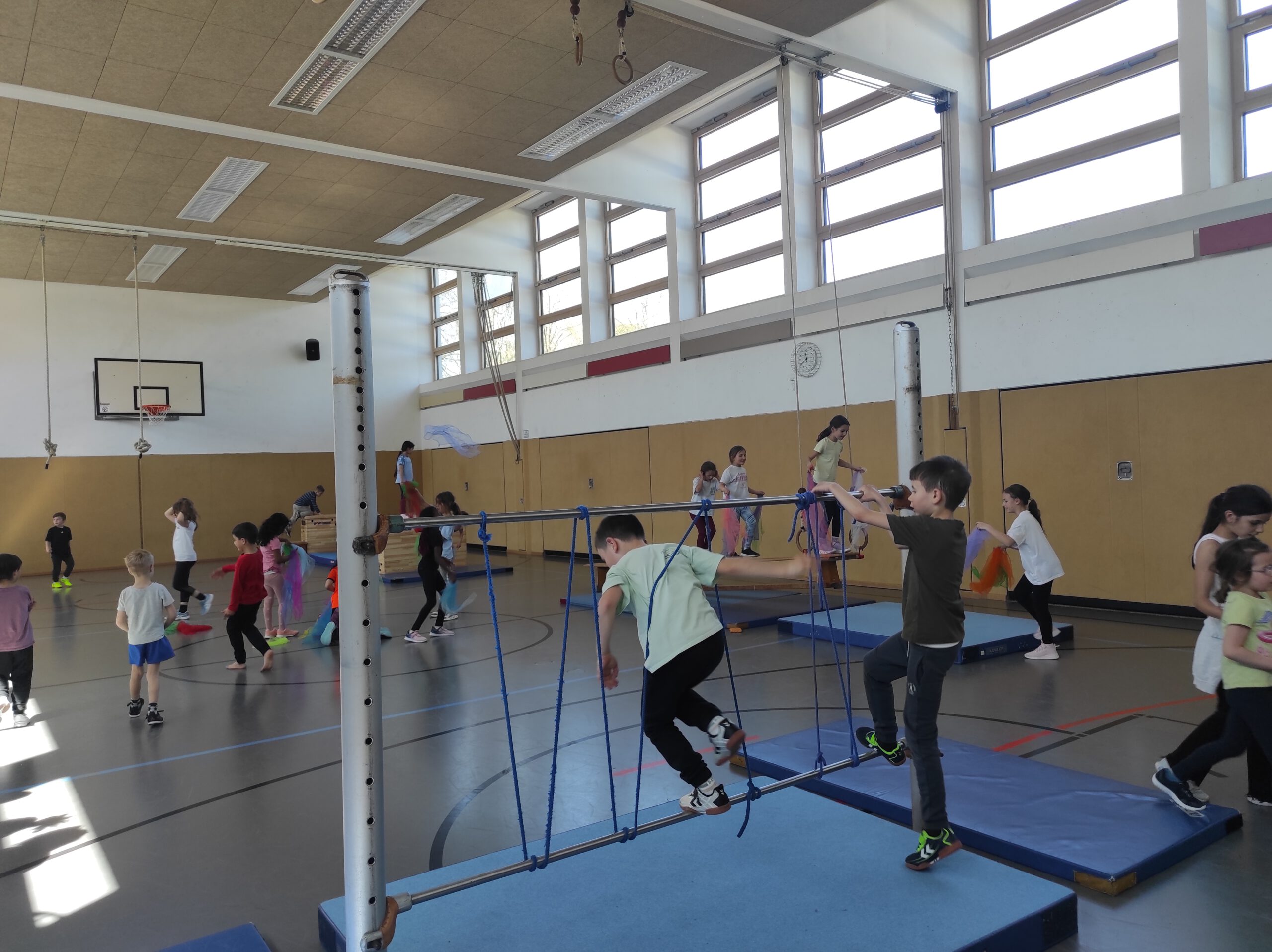 Kinder aus Schule und Kindergarten turnen in der Bewegungslandschaft in der Turnhalle