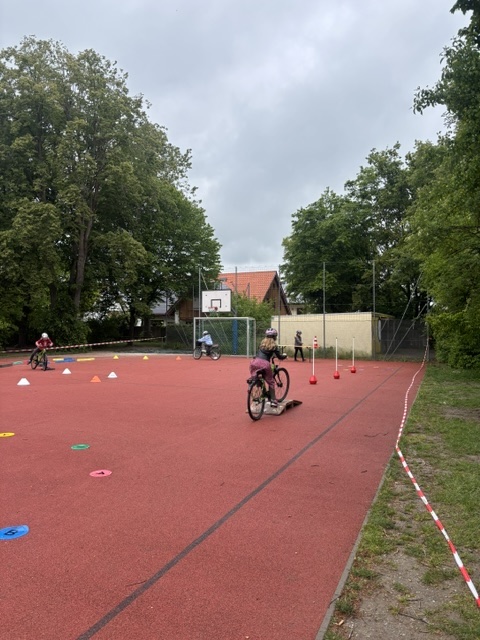 Kinder fahren auf dem Übungsparcours Fahrrad